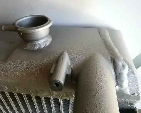 Cordones de soldadura en el depósito de aluminio de un radiador, alrededor de la boca de llenado y en la unión con el panal.